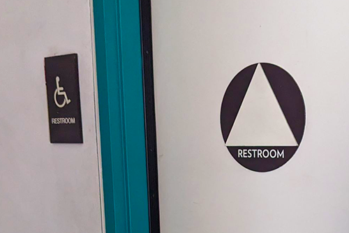 bathroom door with all gender sign