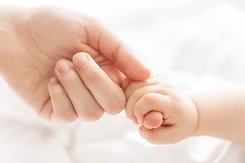 mother and infant hands together