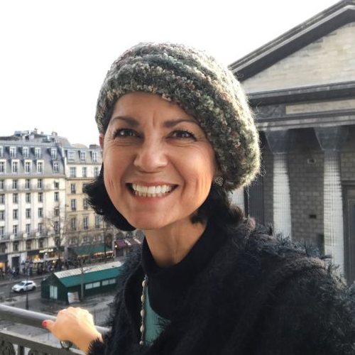 Madeleine Falco on a balcony wearing a knit beret